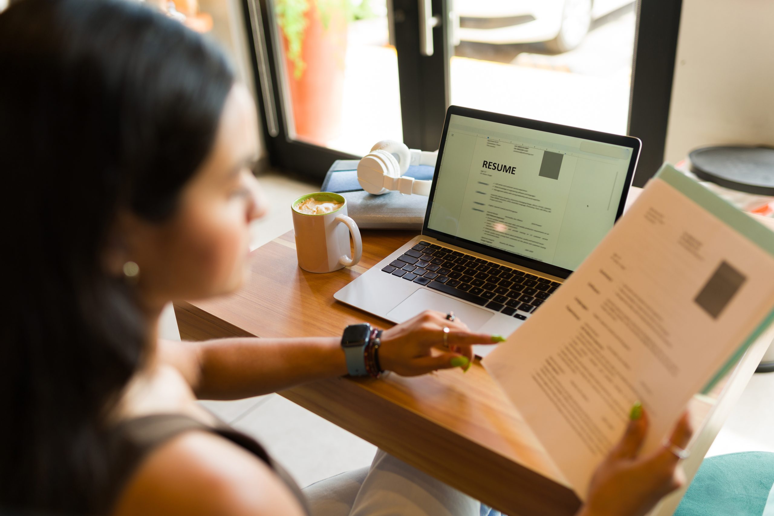 Comment réussir à trouver une entreprise pour son alternance avec INEAD. Jeune femme regardant un CV devant un ordinateur.