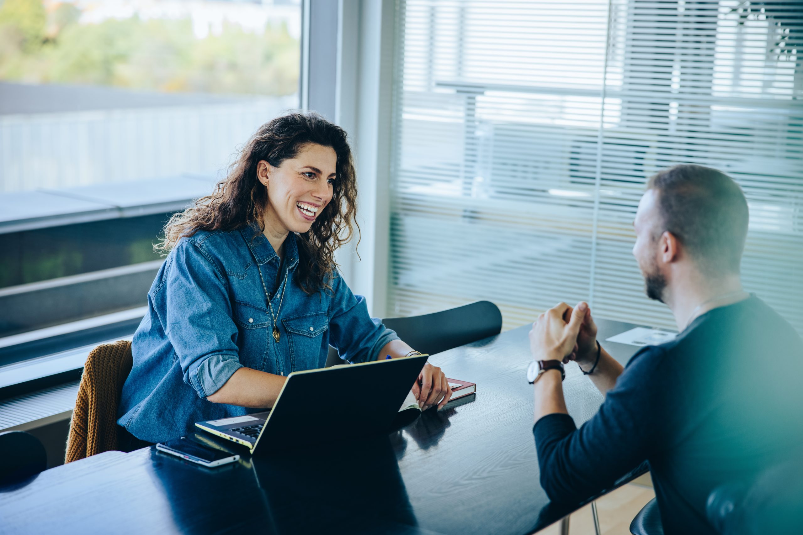 Recruter en alternance ou en apprentissage avec INEAD. Conversation professionnelle et souriante entre une responsable de recrutement et un candidat. 