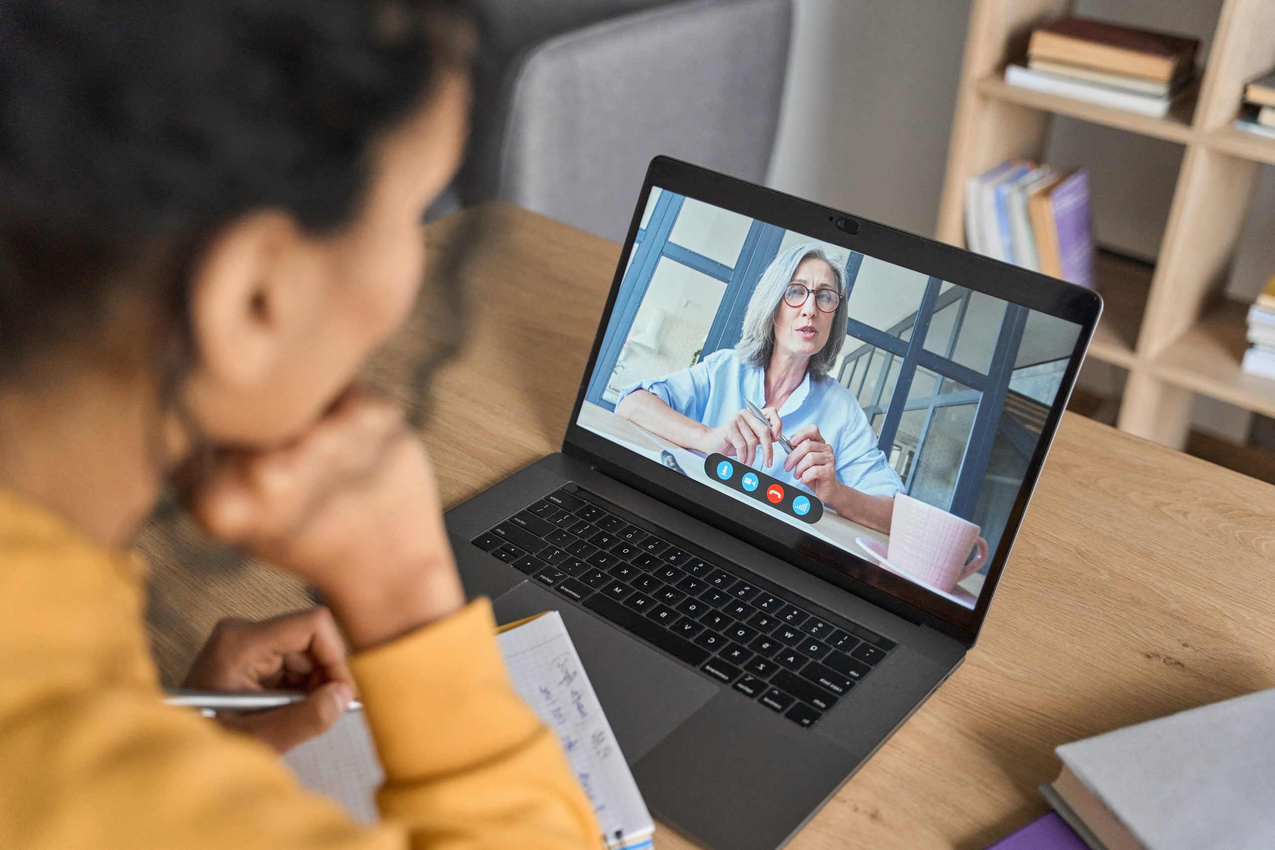 Présentation INEAD, école en ligne. Femme en visio-conférence, suivant un cours en e-learning sur son ordianteur, en one-to-one.