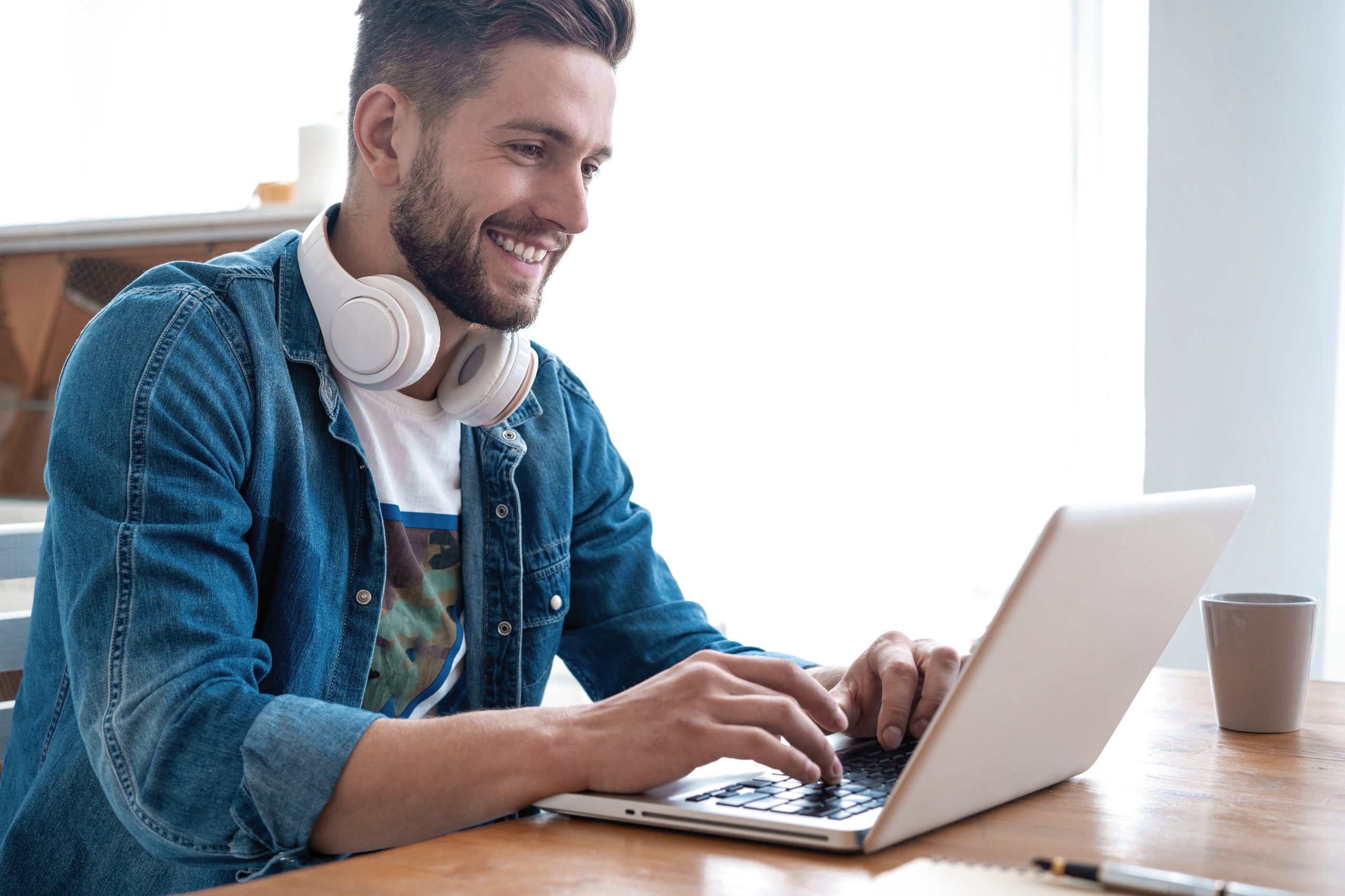 Parcours de formation chez INEAD, école en ligne. Homme souriant travaillant sur son ordinateur portable.